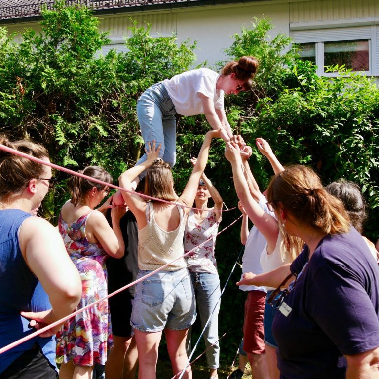 Teamarbeit / Teamentwicklung Ein Team bei einem erlebnispädagogischen Spiel